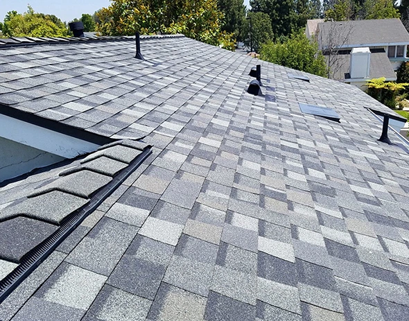 Gray 3-tab shingle roofing on a residential home. New roof installation.