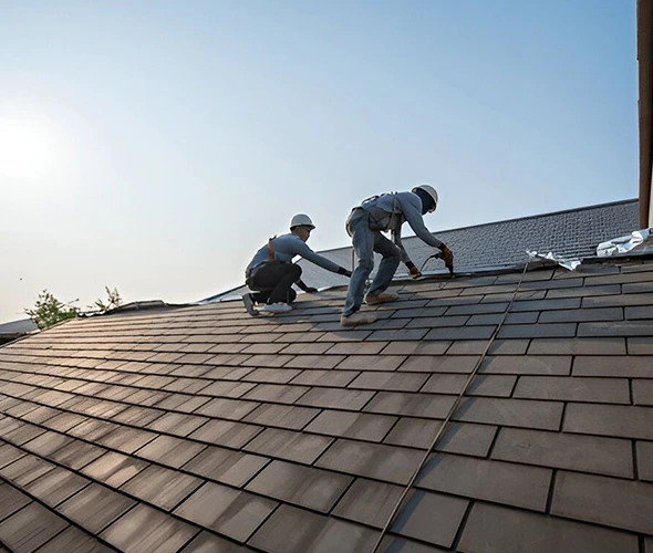 Two workers are installing a tile roof.